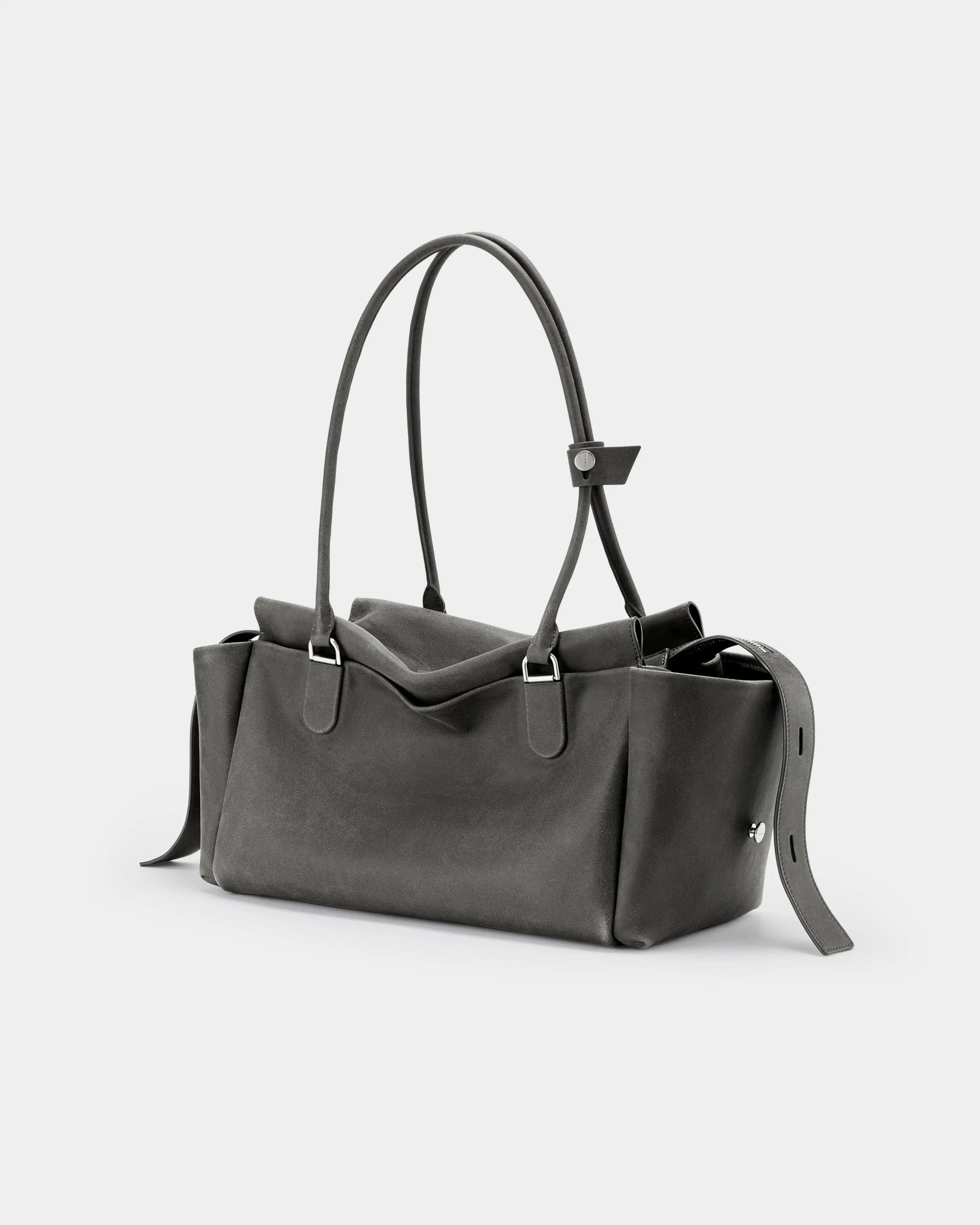 Side profile of the distressed grey-brown cow leather Cargo Maxi bag, highlighting the practical side pockets and sturdy strap construction