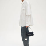 Model-holding-TAD-FAB-Softie-Mini-matte-black-calfskin-shoulder-bag-full-look-side-view