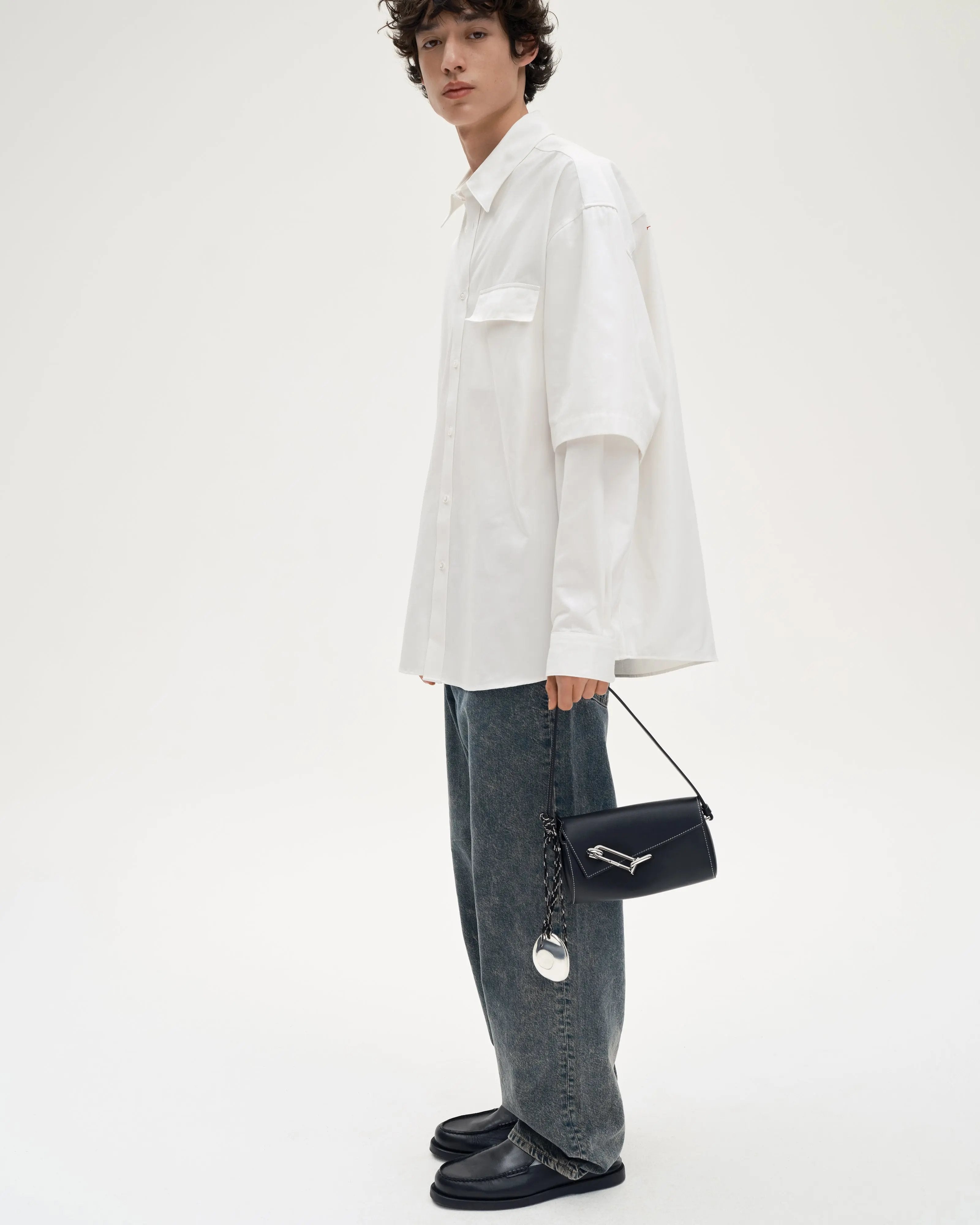 Model-holding-TAD-FAB-Softie-Mini-matte-black-calfskin-shoulder-bag-full-look-side-view